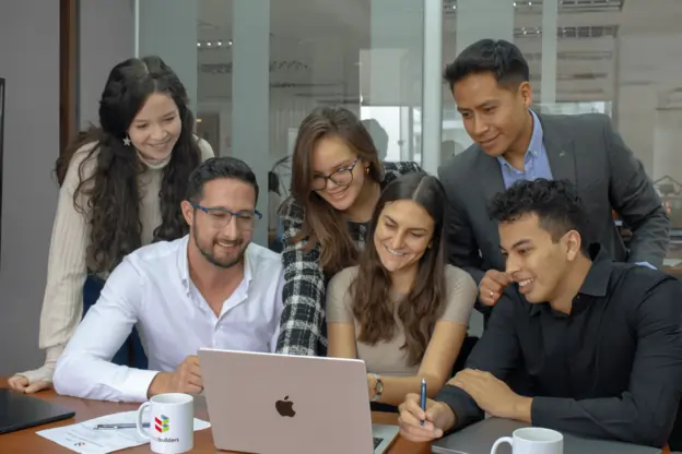 Group of Ecuador Office employees looking at a laptop screen