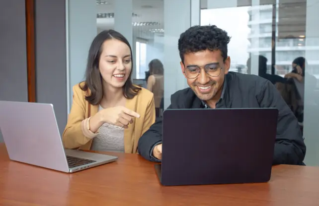 A couple of Ecuador employees working on their laptops