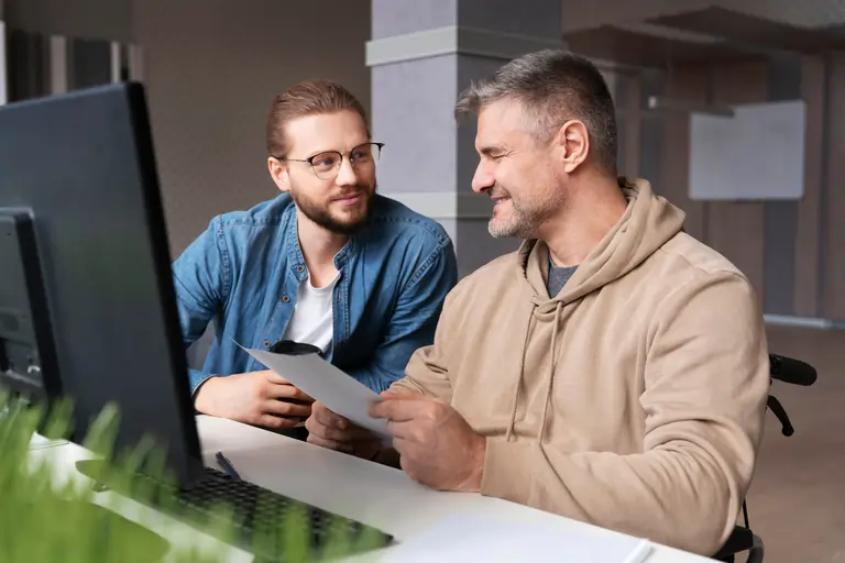 A couple of people working on a laptop