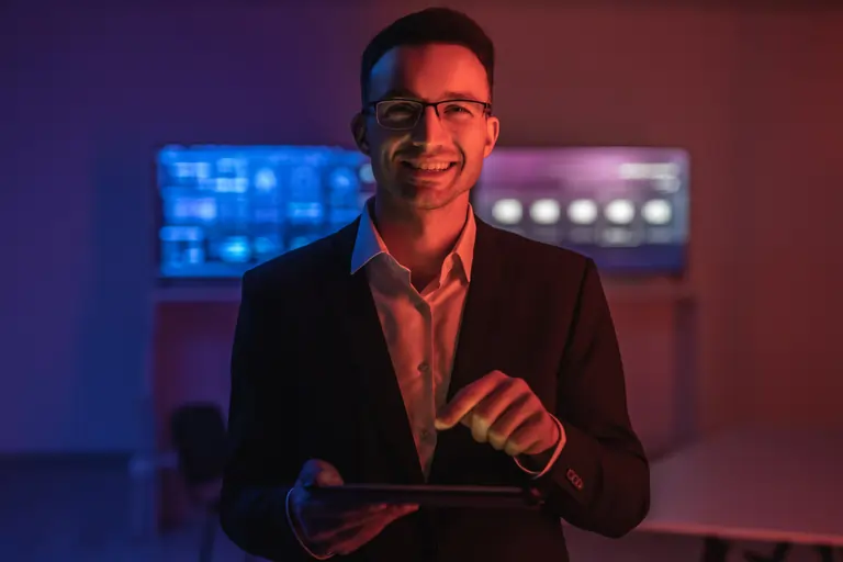 Happy man glasses working with a tablet in a dark room